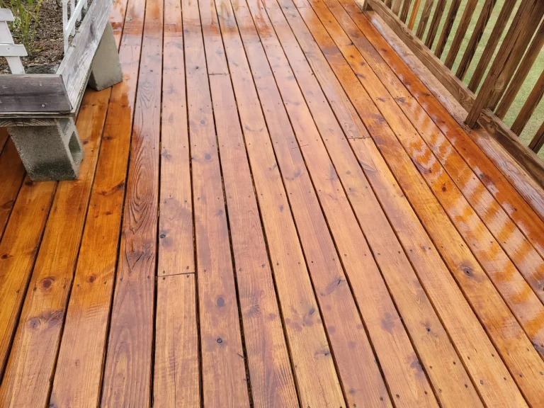 Freshly stained warm wood deck with railing and outdoor furniture