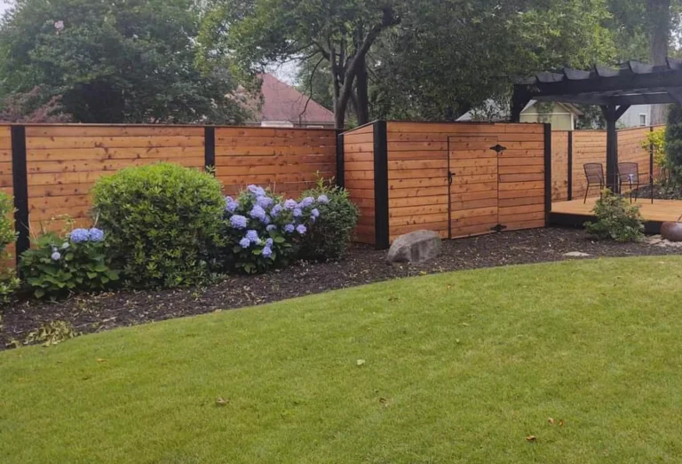 Warm stained horizontal wood privacy fence along a landscaped yard